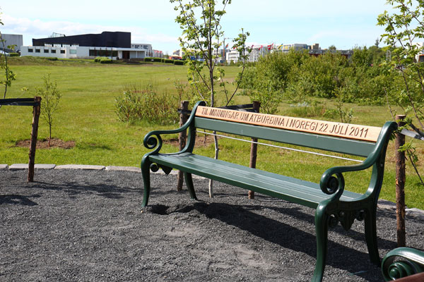 Efra borðið í baki garðbekkjanna í minningarlundinum er úr mahoní og á það er letrað á fjórum tungumálum, einu á hverjum bekk. aletradur-bekkur